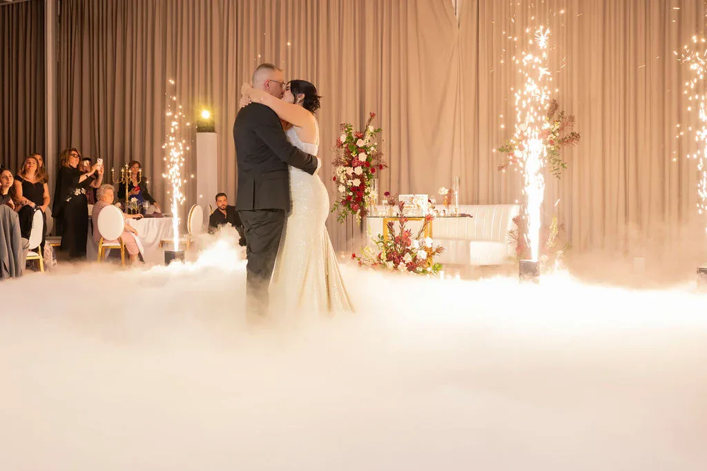 Cold spark fountains and a low dry ice cloud around a couple during their first dance