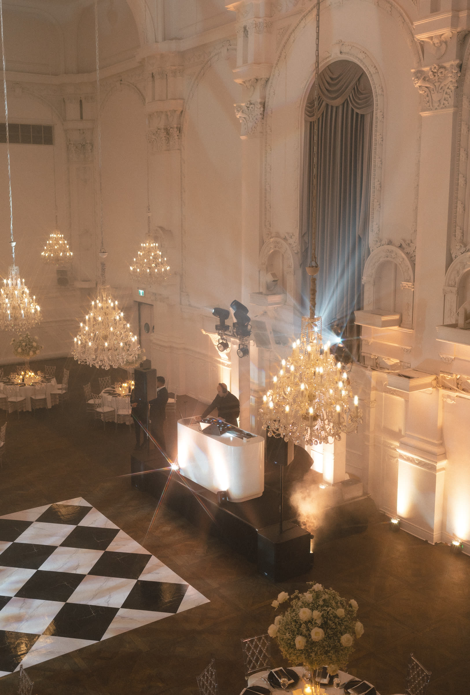 The DJ booth under chandeliers at Maison Principale